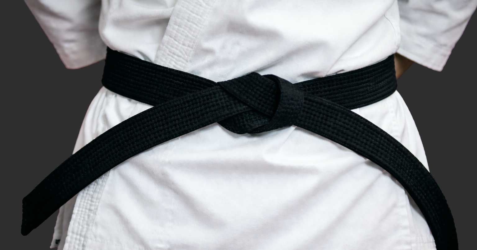 Close-up of a black belt tied around a gi